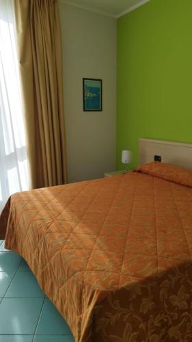 Montepaone LidoにあるVIDA B&B Ristorante Pizzeriaのベッドルーム1室(大型ベッド1台、オレンジ色の掛け布団付)