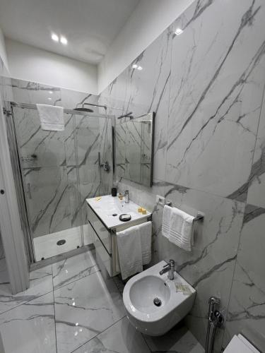 a bathroom with a toilet and a sink and a shower at Lady Mary's Luxury Suites in Naples