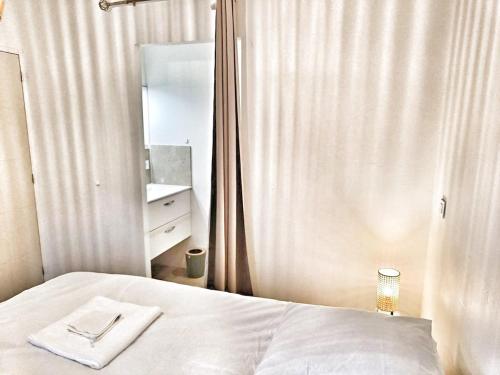 a bedroom with a white bed and a mirror at Au sommet des Ocres et des Bois - Maison T3 & Parking in Roussillon