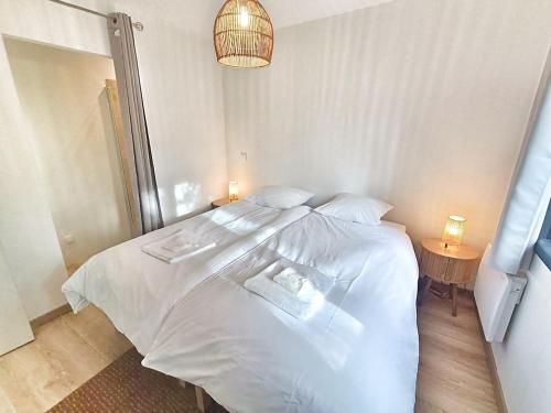 a large white bed in a bedroom with a lamp at Au sommet des Ocres et des Bois - Maison T3 & Parking in Roussillon