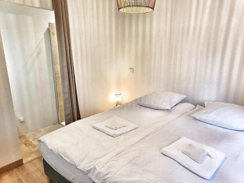 a white bed with two towels on top of it at Au sommet des Ocres et des Bois - Maison T3 & Parking in Roussillon