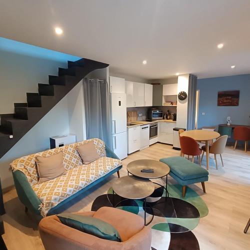 a living room with a couch and a table and a kitchen at Au sommet des Ocres et des Bois - Maison T3 & Parking in Roussillon