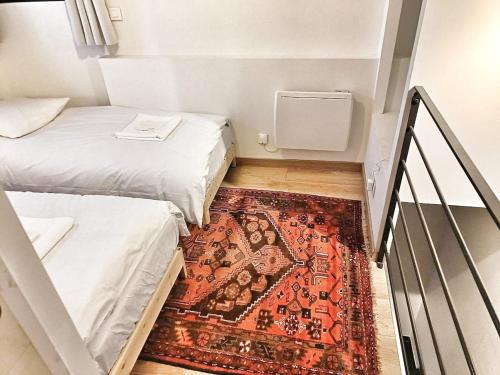 a small room with two beds and a rug at Au sommet des Ocres et des Bois - Maison T3 & Parking in Roussillon
