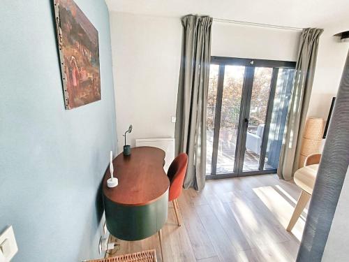 a living room with a table and chairs and a window at Au sommet des Ocres et des Bois - Maison T3 & Parking in Roussillon
