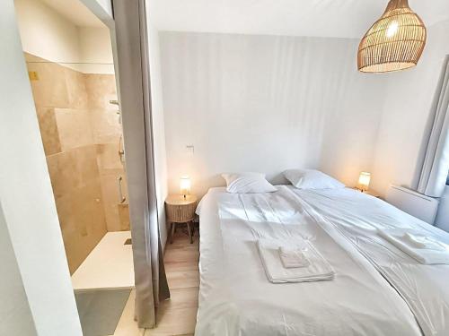 a bedroom with a white bed and a bathroom at Au sommet des Ocres et des Bois - Maison T3 & Parking in Roussillon