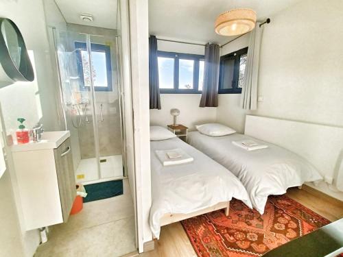 a small room with two beds and a mirror at Au sommet des Ocres et des Bois - Maison T3 & Parking in Roussillon