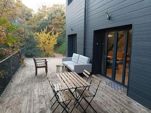 a patio with a couch and a table and a chair at Au sommet des Ocres et des Bois - Maison T3 & Parking in Roussillon