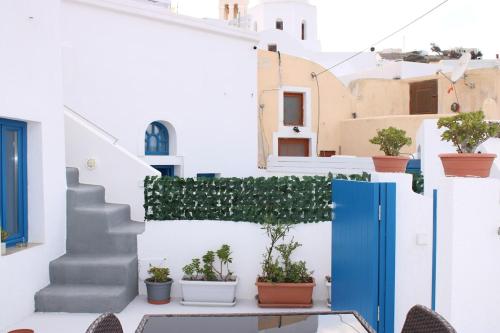 a house with a blue door and potted plants at Mary Castelia Villa with Jacuzzi in Akrotiri