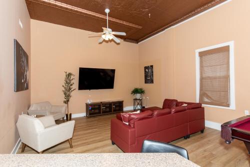 a living room with a red couch and a flat screen tv at The Jazz Club Downtown Sandusky in Sandusky