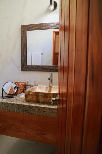 a bathroom with a wooden sink and a mirror at Hacienda Cenote San Ignacio in Chocholá