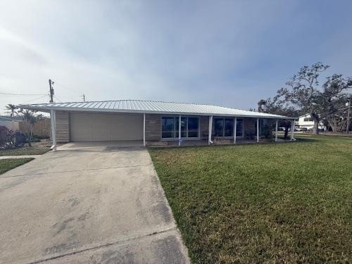 a house with a garage and a grass yard at Pool home on the Bay, large private yard near AMI in Bradenton