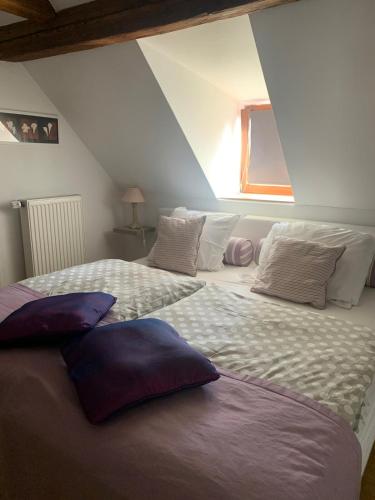 une chambre avec deux lits avec des oreillers dessus dans l'établissement Gite Chez Joséphine - La chambre du Clocher, à Dambach-la-Ville