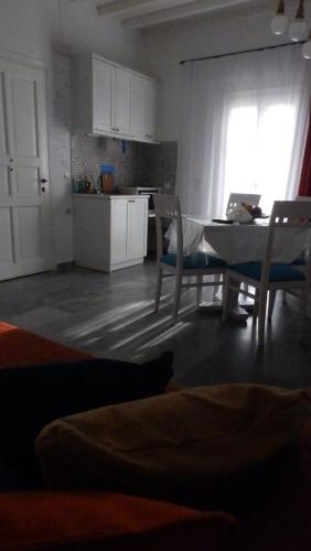a living room with a table and chairs and a kitchen at Mykonos Ornos Turquoise Home in Ornos