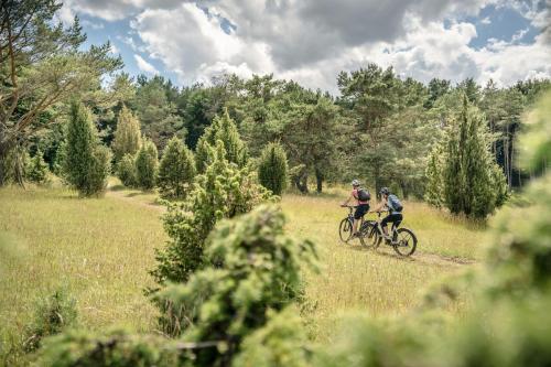 two people riding bikes on a trail in a field at Exklusive Cabins am Rursee inmitten der Natur – mlab relax Eifel in Simmerath