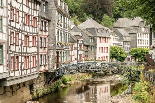 a bridge over a river in a city with buildings at Exklusive Cabins am Rursee inmitten der Natur – mlab relax Eifel in Simmerath