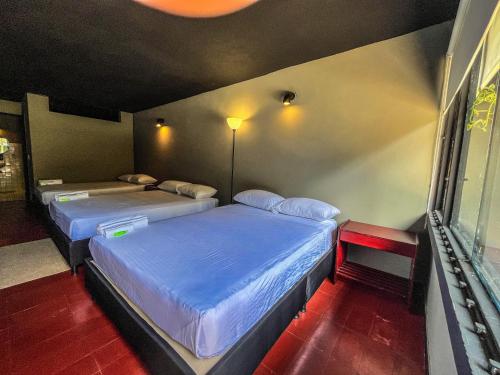 two beds are in a room withthritisthritisthritisthritisthritisthritisthritisthritisthritis at Antonia Poolside Autonomy Hotel in Ibagué