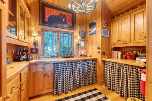 a kitchen with wooden cabinets and a sink at Homewood Lakefront by AvantStay Private Beach Lake Access Views in Homewood