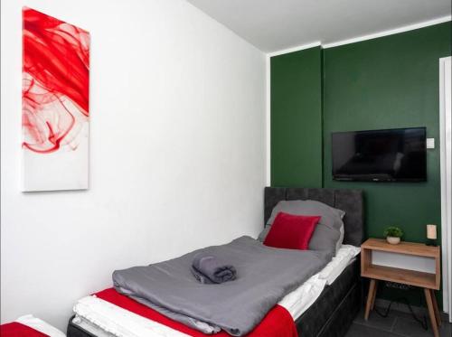 a bed in a room with a green wall at Livemore24 - Apartment 2 in Oer-Erkenschwick WLAN in Oer-Erkenschwick