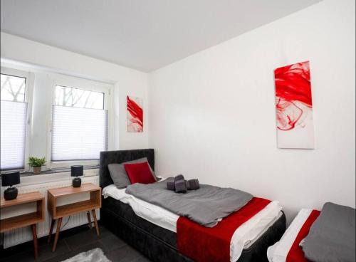 a bedroom with a bed and a desk and two windows at Livemore24 - Apartment 2 in Oer-Erkenschwick WLAN in Oer-Erkenschwick