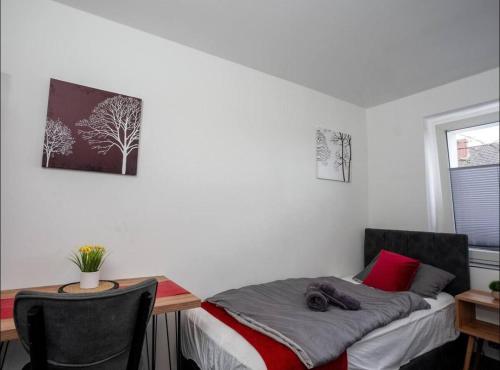 a bedroom with a desk and a bed and a table at Livemore24 - Apartment 2 in Oer-Erkenschwick WLAN in Oer-Erkenschwick