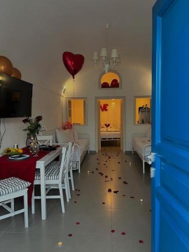 a room with a table and a heart balloon on the floor at Mary Castelia Villa 2 with Jacuzzi in Akrotiri