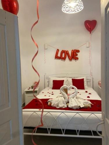 a bedroom with a bed with a love sign on the wall at Mary Castelia Villa 2 with Jacuzzi in Akrotiri