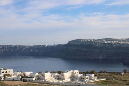 a group of white buildings next to a body of water at Mary Castelia Villa 2 with Jacuzzi in Akrotiri