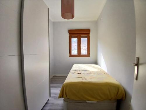 a small bedroom with a bed and a window at Entrepinos in Guisando