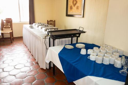 a row of tables in a room with blue and white tables at Hotel Hacienda Bugambilias in La Paz