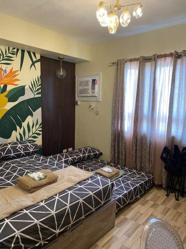 a bedroom with two beds and a painting on the wall at La Vie Suite at MesaVerte Residence in Cagayan de Oro