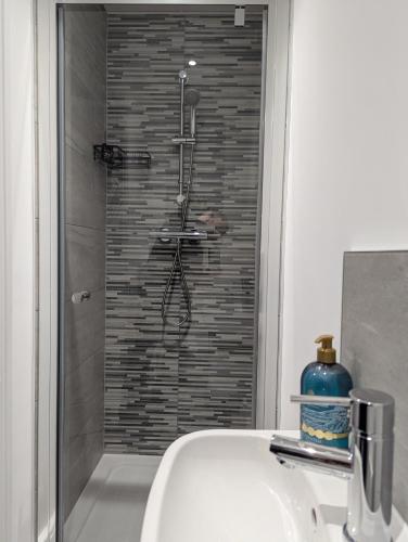 a shower in a bathroom with a sink at Large 4 Bed Hse, Sleeps 7, 3 BTH, Drive PRKG-4 Cars, M4-A329, Shinfield Studios, 10mins, Reading, Ascot & Legoland 20mins, Film Crew, Contractor & Family Friendly in Winnersh