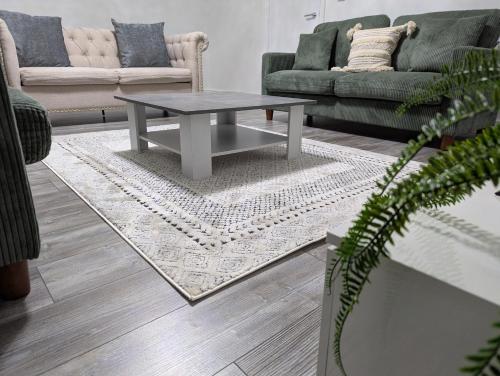 a living room with a coffee table on a rug at Large 4 Bed Hse, Sleeps 7, 3 BTH, Drive PRKG-4 Cars, M4-A329, Shinfield Studios, 10mins, Reading, Ascot & Legoland 20mins, Film Crew, Contractor & Family Friendly in Winnersh