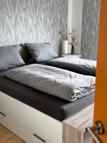 a bed with a black and white comforter and pillows at Ferienwohnung Weitblick in Erftstadt