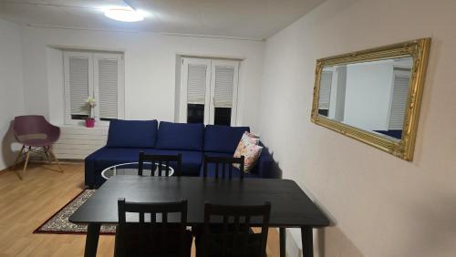 a living room with a blue couch and a table at Muhusin Apartments Trimbach in Trimbach