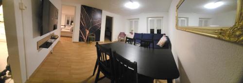 a dining room with a black table and chairs at Muhusin Apartments Trimbach in Trimbach