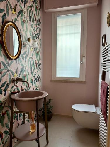 a bathroom with a sink and a toilet and a window at Baki B&B in Rimini