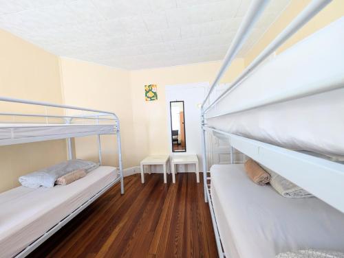 two bunk beds in a room with wooden floors at Boston Homestel in Boston