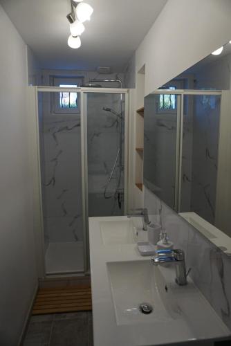 une salle de bain avec un lavabo blanc et une douche dans l'établissement Maison de la côte Saint Amand, à Le Vernet