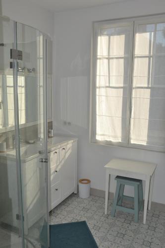 une salle de bain avec une douche et un tabouret dedans dans l'établissement KERJACNINE, à 300 m du port, maison 7 couchages avec grand jardin, au Pouliguen