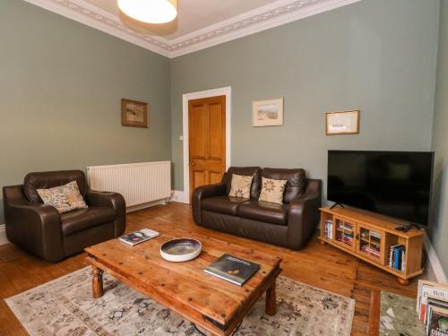 a living room with two couches and a television at Struan House in Aberfeldy