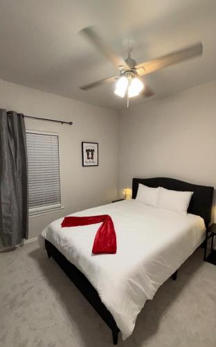 a bedroom with a large white bed with a ceiling fan at Hill Country Hilltop Haven in Bee Cave