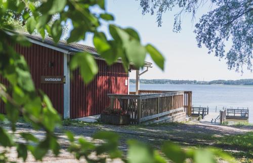 a building with a picnic table next to the water at Majvik Congress Hotel in Kirkkonummi