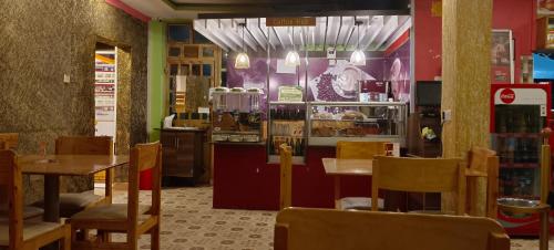 a restaurant with tables and chairs in a room at Motel Clavina in Gilgil