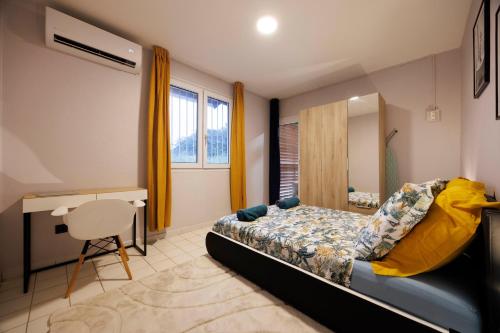 a bedroom with a bed and a desk and a chair at L'Eldorado - DestinationGuyane in Bourda