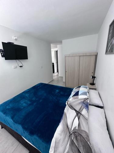a bedroom with a large bed and a flat screen tv at Apartamento Norte de Armenia Salida para Salento y Filandia in Armenia