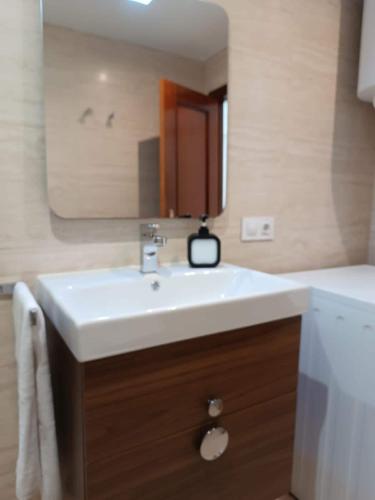 a bathroom with a white sink and a mirror at Fleming's Beach in Puebla de Farnals