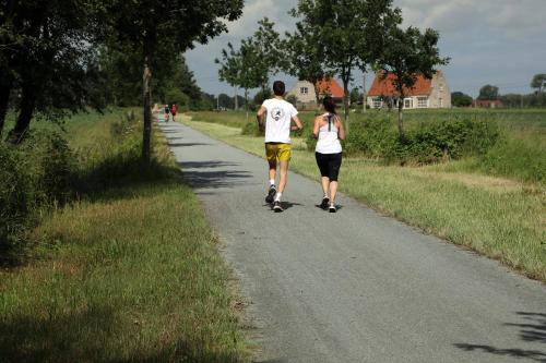 a man and a woman walking down a road at Gastenkamers Boussemaere in Ichtegem
