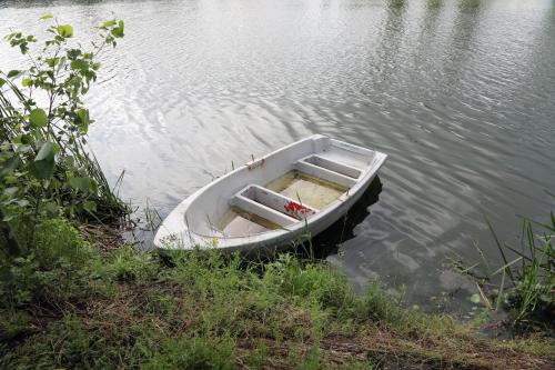 a small boat sitting in the middle of the water at Gastenkamers Boussemaere in Ichtegem