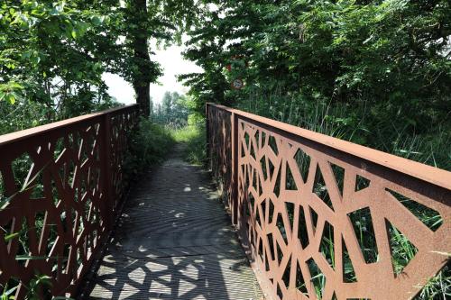 a wooden bridge with a walking path on it at Gastenkamers Boussemaere in Ichtegem
