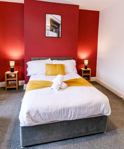 a bedroom with a large bed with red walls at 2 Bedroom Home-Free Parking-Perfect for Contractors in Pallion